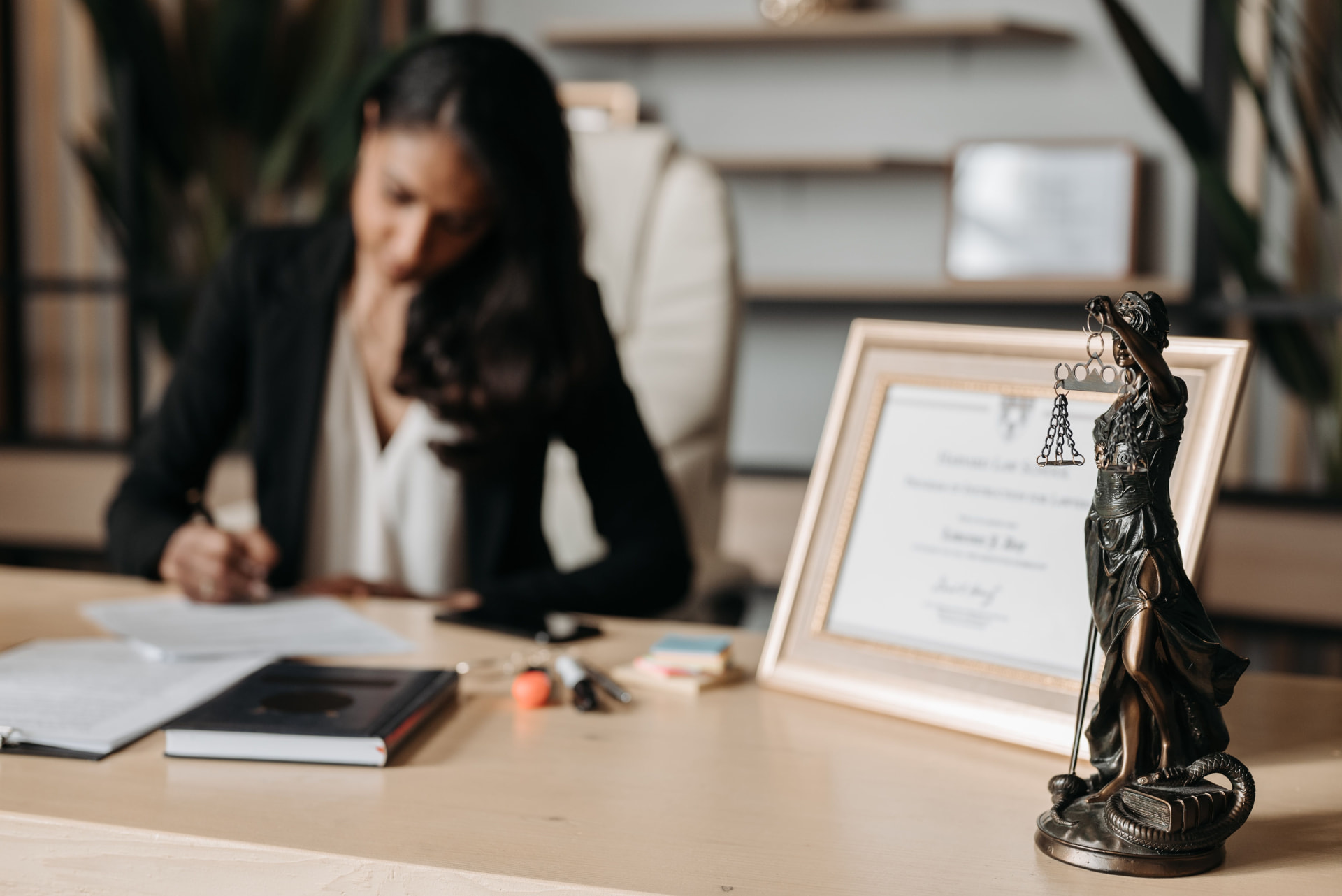 A lawyer writing at her desk in a law office